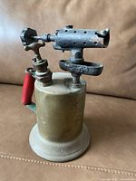 Photo showcasing the full vintage brass blow torch with valve and nozzle.