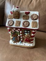 Front view of the Christmas gingerbread house cookie jar with decorative candy and gingerbread figures on the exterior.