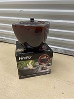 Photo of a brown ceramic fire pot with lid on its original box labeled 'Fire Pot'.