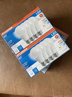 Two unopened packs of Sylvania LED light bulbs, each pack containing four 60 watt equivalent bulbs, labeled with 800 lumens and soft white 2700K.