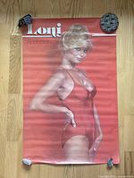 Full view of the vintage Loni Anderson poster on a wooden floor, showing wrinkles and slight wear.