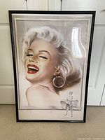 Framed vintage Marilyn Monroe poster, 24x36 inches, showing a detailed close-up of Marilyn smiling with her iconic look and a smaller figure in the bottom right corner.