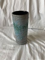 Photo of a single vintage ceramic vase with textured exterior featuring green and gray colors.