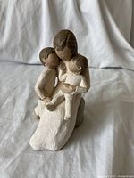 Front view of the figurine showing mother with two kids in an embracing pose.