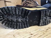 Close-up of thick rugged sole showing minimal wear and typical grip pattern.