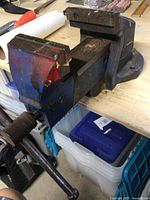 View of the entire heavy bench vice mounted on a workbench showing the jaw and handle.