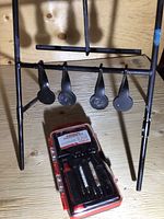 Chainsaw chain target with four metal circular spinning targets mounted on a tripod stand