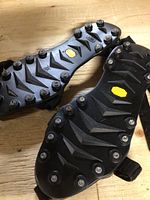 Close up of black Icer's ice grips soles showing metal studs for traction on ice.