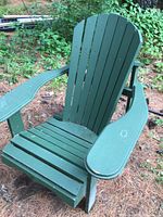 Front and left side view of the green wooden Muskoka chair showing the wide armrests and slatted seat and back.