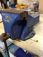 Side profile of blue metal Record No 100 workshop vice showing jaws and handle