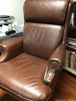 Front view showing seat cushion, rolled arms, nailhead trim