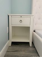 Front view of first bedside table showing drawer and shelf