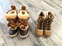 Both pairs of boots side by side on wood floor