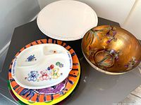 Overview of ceramic cake stand, handmade glass bowl, and various plates including child’s divided plate