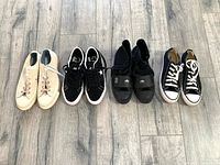 Four pairs of men's Converse sneakers arranged side by side showing different colors and styles, reflecting lightly used condition.