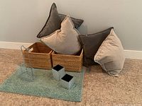 Photo showing the 4 cushions in beige and brown tones, two basket holders, the metal shower caddy, and the green bathroom mat placed on carpet.