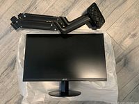 Top view of the monitor with the mounting arm placed beside it on a cloth.