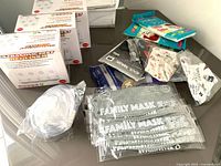 Photo of three boxes of Ultrasonic Pest Repellers and multiple face masks including family masks and CPR masks displayed on a surface.