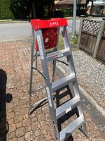 Full view of the aluminum stepladder showing its folding structure and red top with the brand name Eagle.