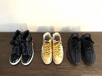 Front view of all three pairs: black patent leather, gold Golden Goose, black Yeezy Boost