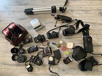Overview of seven cameras, lenses, tripods, flashes, filters, chargers, carrying case