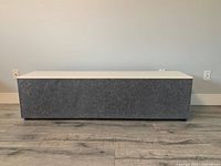 Front view of closed cabinet showing grey fabric door and white top