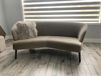 Front view of angled sofa with one shaggy grey cushion