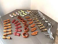 Full view of all sets spread on a table with various wooden and metal napkin rings and chopstick holders.