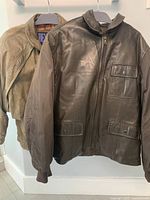 Two jackets hanging side by side showing both front views