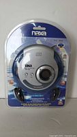 Front view of the Naxa NX-368 portable CD player in original sealed packaging showing player and headphones inside.