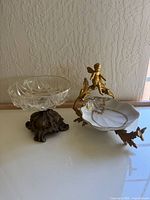 Cut glass dish with scalloped edge on an ornate bronze base, showing crystal pattern and base detail.