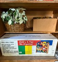 Photo of package box on shelf showing Longs Drug Stores branded child's 4-tier bin organizer with multi-color bins and some contents inside the bins as pictured on box graphic.