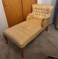 Full view of the French fainting chaise longue showing carved wooden legs, armrests and upholstery