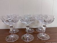 Set of six Gorham cut crystal champagne sherbet glasses showing clear crystal with intricate cut pattern, faceted stems, and starburst bases.