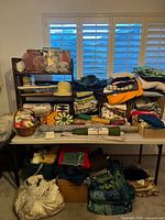 Full view of table and shelving with stacked fabrics, baskets, and fabrics on floor below