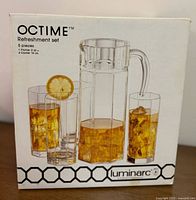 Photo of packaging box showing 5 piece refreshment set with pitcher and four cooler glasses filled with iced tea and a lemon slice on one glass.