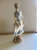 Front view of Royal Doulton figurine showing the woman and floral details on dress and base