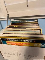 Photo showing a side view of many vintage vinyl records stacked vertically, visible record titled Merengues and Mambos by Fred Astaire