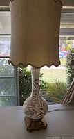 Full view of the vintage lamp showing ceramic base, brass footed stand, and scalloped fabric lampshade