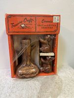 Front view of vintage Treasure Craft ceramic salt and pepper shakers in original orange box with bears and tree.