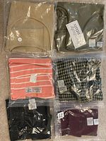 Six ladies blouses individually packaged in clear plastic showing variations in styles and colors