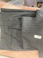 Gray pinstripe trousers folded and labeled with '66'.