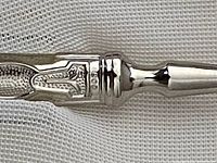 Close-up of handle showing '800' silver hallmark and engraved scrolling pattern.