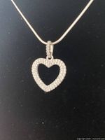 Close-up of the silver heart-shaped pendant necklace showing pendant details.