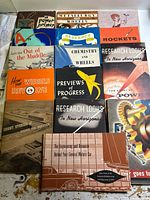 All sixteen booklets laid out showing front covers and variety of titles