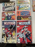 Front view of nine bagged comic books showing titles King-Size Thor, King-Size Captain America, Daredevil, Uncanny X-Men, Wolverine, Dark Horse Presents