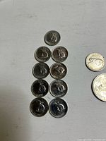 Nine 1967 Canadian Centennial nickels displayed in columns plus partial view of other coin