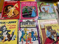 Front covers of six Little Golden Books including Sonny the Lucky Bunny, Peter Pan and Wendy, Bambi, Tom and Jerry Meet Little Quack, Sesame Street The Together Book, Good Night Little Bear