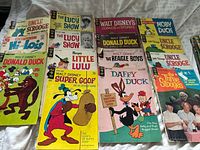 Top-down view showing 11 comics laid out including Uncle Scrooge, Lucy Show, Comics & Stories, Moby Duck, Donald Duck, Super Goof, Daffy Duck, Three Stooges