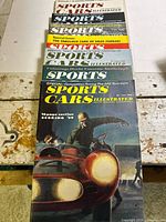 Stack of seven Sports Cars Illustrated issues showing spines and cover edges